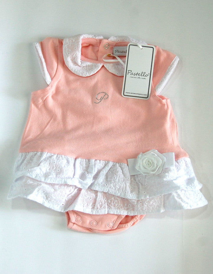 Pagliaccetto da neonata rosa con colletto, alette sulle spalle e volant in pizzo bianco, con rosellina in raso di lato