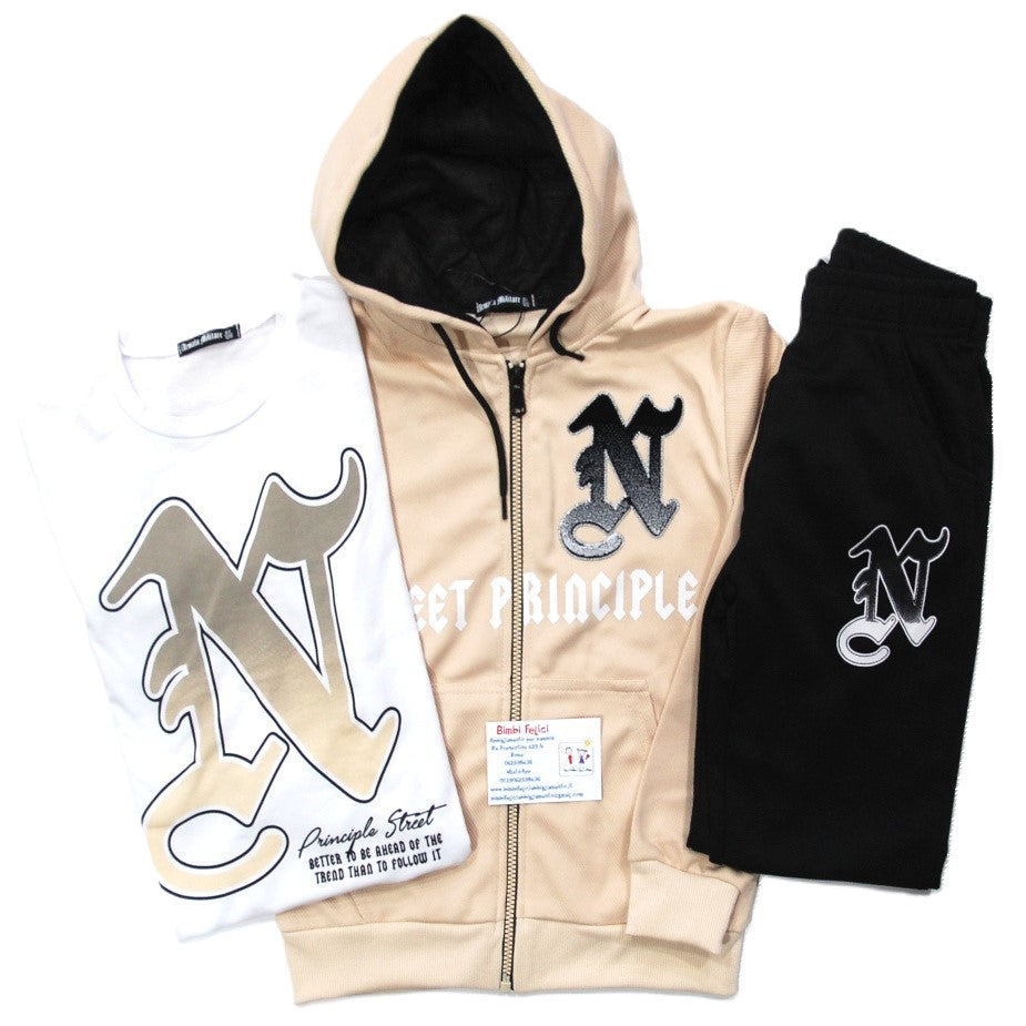 Tuta da ragazzo composta da felpa beige con fodera del cappuccio nera, pantaloni neri e t-shirt bianca.