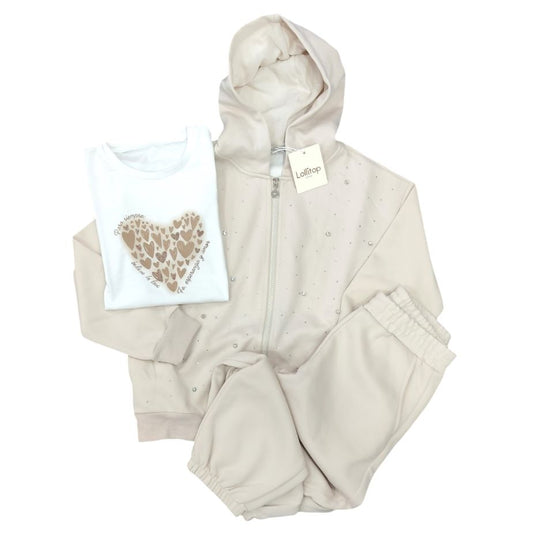 Completo tre pezzi da ragazza Lollitop Style composto da un giubbino beige leggero con cappuccio e piccoli strass, una t-shirt bianca con un cuore beige sul davanti e un pantalone jogger beige coordinato, disposti su sfondo bianco.